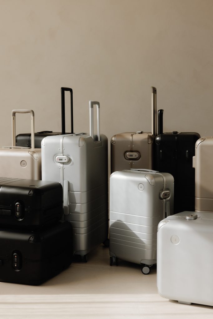 Collection of suitcases ranging in different sizes and made of various materials like metal and black plastic.